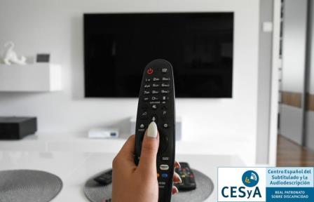 Foto de una televisión y una mano sosteniendo un mando a distancia con logotipo del CESyA