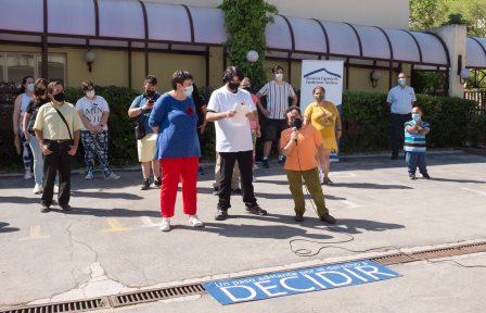 Foto de la reunión del acto en el exterior de las instalaciones del Real Patronato sobre Discapacidad, con personas con discapacidad y una pancarta con el texto Derecho a Decidir, y Jesús Martín Blanco