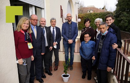 Foto de familia de las personas asistentes al acto con el árbol plantado en memoria de las personas con discapacidad víctimas de la COVID-19