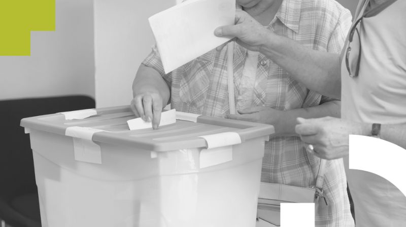 Imagen de una persona insertando su voto en una urna